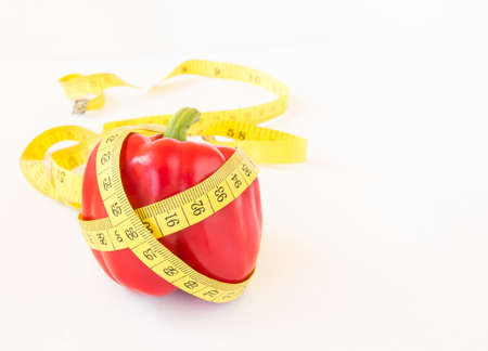 Yellow tape measure and sweet pepper on white background. Healthy lifestyle conceptの写真素材