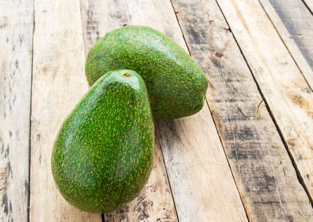 Fresh green avocado on wooden table backgroundの写真素材
