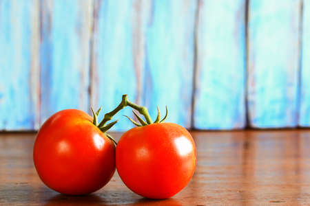 Close up fresh red tomato on wooden table with copy space for designの写真素材
