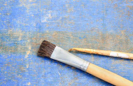 Paint brush on blue wooden table background.の写真素材