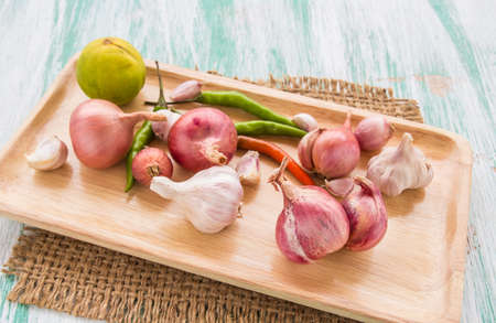 Fresh organic red onion garlic and lemon on a wooden backgroundの写真素材