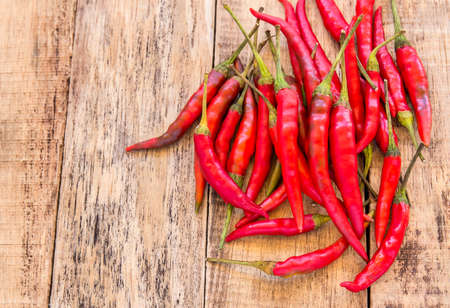 Red hot chili peppers on old wooden table backgroundの写真素材