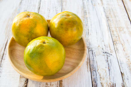 Tangerines on a white wooden table backgroundの写真素材