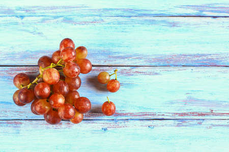 Close up fresh red grape on wooden table top view with copy space