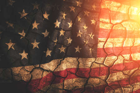 Background is an aged cracked flag United States of America illuminated by sunの写真素材