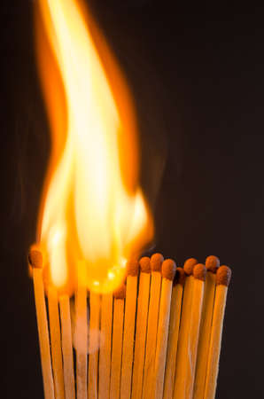Burning matches with orange flames on a black backgroundの写真素材