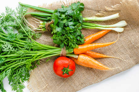 Carrots, parsley,leeks and tomatoes are dried on burlap. Summer and healthy vegetables.