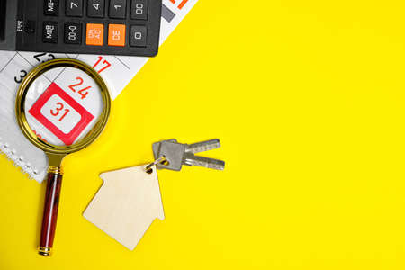Calendar End of the Month Calculator Keys to a House or Apartment on a Yellow Background Concept Buying an Apartment House New Year Giftの写真素材