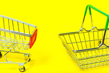 Shopping cart and shopping cart on yellow backgroundの写真素材