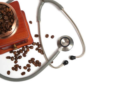 Stethoscope and coffee grinder with coffee beans on a white backgroundの写真素材
