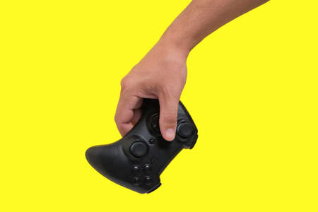 Gaming joystick for games in hand on yellow background