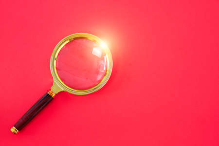 Magnifying glass on a bright red backgroundの写真素材