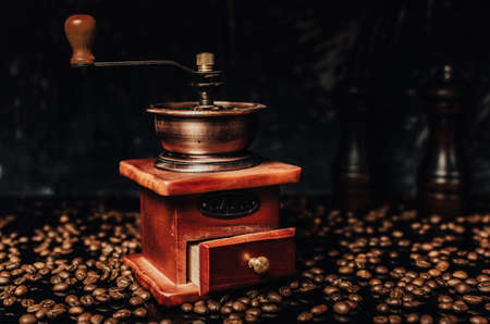 Old wooden coffee grinder and coffee beans on concrete background.の写真素材