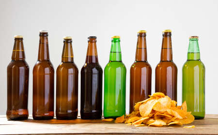 Beer bottles and potato chips on a wooden table. Top view. Selective focus. Mock up. Copy space.Template. Blank.の写真素材
