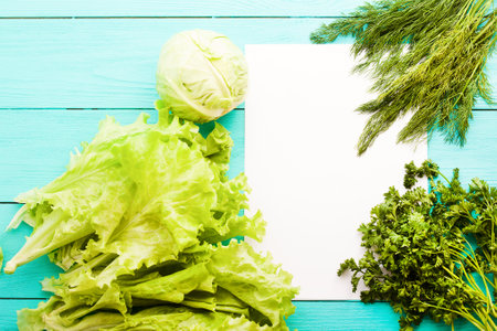 Different vegetables on kitchen table with recipe list and copy space. Top view and selective focusの写真素材