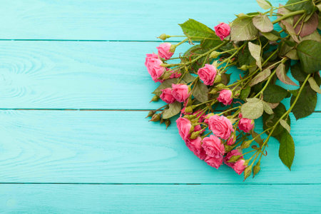 Frame of colorful roses on blue wooden background. Top view and selective focus. Copy space and mock up, Valentine and mother dayの写真素材