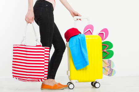 girl with suitcase isolated on white background .Summer holidays. summer flip flops or slippers. Travel valise or bag. Mock up. Copy space. Template. Blank.の写真素材