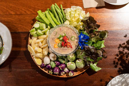 Salted fish dipping sauce with Thai herb and vegetables mixed on wooden tray. Thai food, Local foodの写真素材