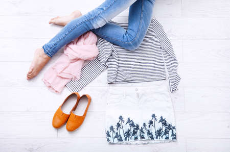 Stylish outfit with accessories and female legs on white wooden background. Top viewの写真素材