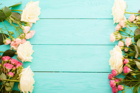 Frame of white roses on blue wooden background with copy spaceの写真素材