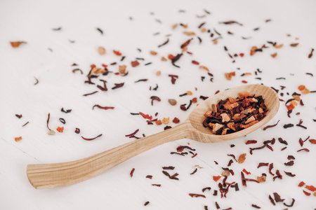 Dry fruit tea in a wooden spoon scattered on a white background. Top view. Copy, empty space for text.の写真素材