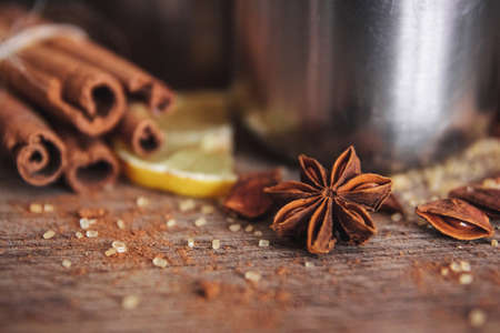 Freshly homemade mulled wine in a bowl with fragrant species, citrus fruits, lemon on a wooden rusric board. Flat lay. Place for text.の写真素材