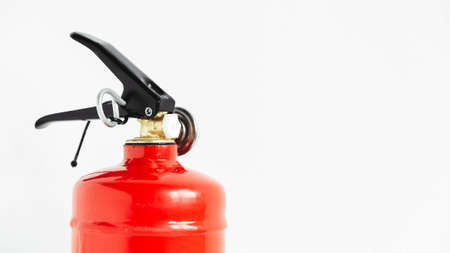 Red fire extinguisher on a white wall background.の写真素材
