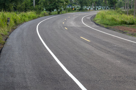 View of the surface of the curved road, which is paved with new renovations, often found in the Thai countryside.の写真素材