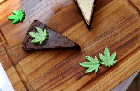 Triangle shape browie with cannabis on wood plate.の写真素材