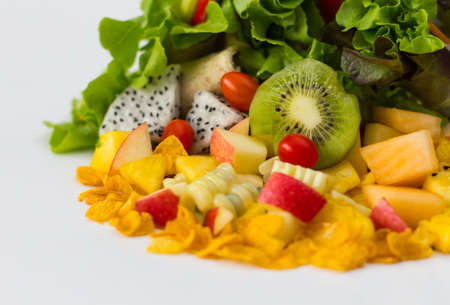 Isolated close-organic salad and fruit pieces putting together piles presumably healthy eating.の写真素材