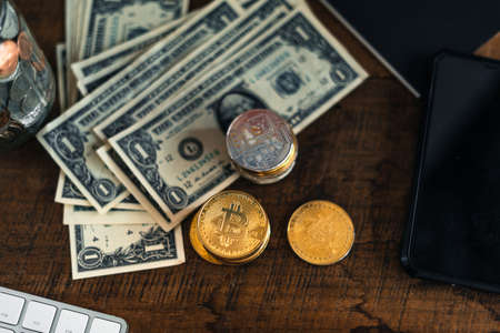 Golden bitcoins placed on a wooden desk in the house.の写真素材