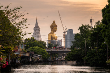 Large golden buddha with pagoda in traditional community on riverside at Bangkok, Thailandのeditorial素材