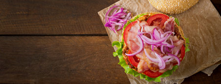 Big sandwich - hamburger burger with beef, red onion, tomato and fried bacon.の写真素材