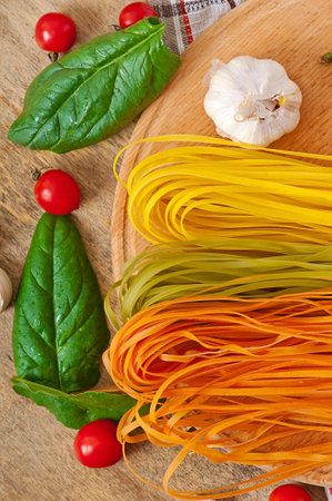 Colorful fettuccine  pasta and cooking ingredients on wooden tableの写真素材