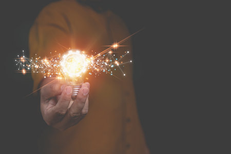 Businessman holding light bulb shine glitter with a gear and brain icon creativity ideas with network connection line. Creativity ideas of inspiration online. Innovation, inspiring, creative concept.の写真素材