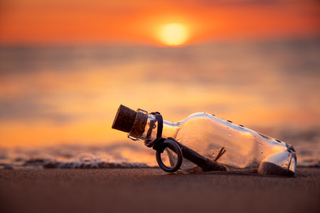 Message in the bottle against the Sun setting downの写真素材