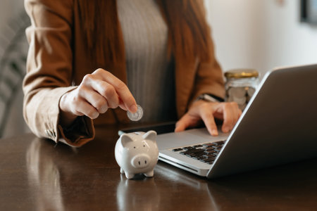 Woman hand holding coin with pig piggy bank. Saving and financial accounts concept