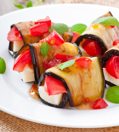 Eggplant rolls stuffed with cheese with a slice of tomatoの写真素材