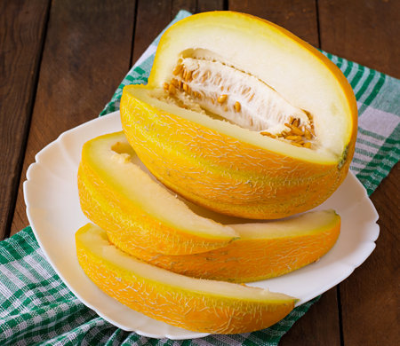 Melon cut into pieces on a plateの写真素材