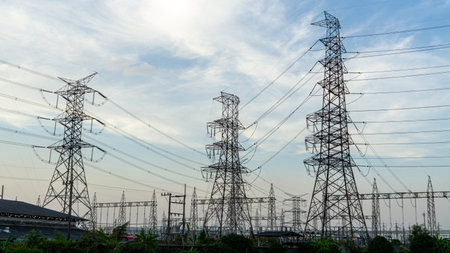 inspection engineer holding tablet computer against high electric power at industry site.