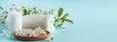 Aromatherapy wellness concept. Spa and relaxation accessories on a blue background. Aromatic oil, towel, candle and flowers. Organic skin care product. Banner formatの写真素材