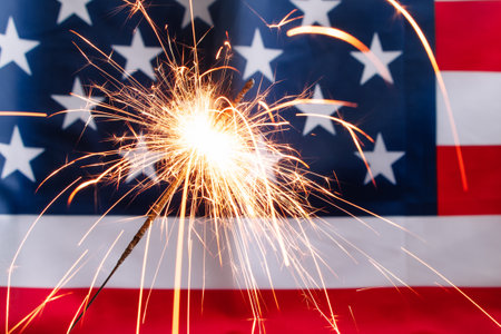 Concept for celebrating US Independence or Memorial Day. Sparkler on a background of the American flag.の写真素材