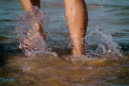 Legs of the girl walking among the small waves of the sea.
Legs of a girl running to the ocean on a...