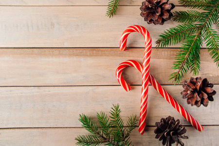 Fir branches and candies on wooden background. Christmas and new year concept. Place for text.