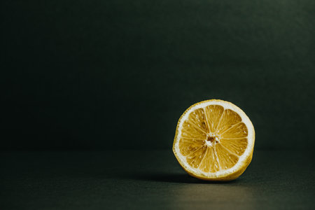 A half of a lemon with a dark green backgroundの写真素材