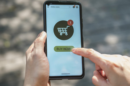 woman shopping online with credit card at coffee shop in outdoor.close up hand holding smartphoneの写真素材