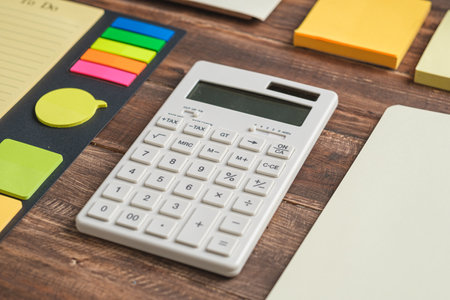 Calculator and note pad planner on wooden office tableの写真素材