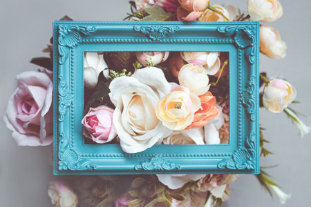 Composition made of photo frame and artificial flowers in pastel colorsの写真素材