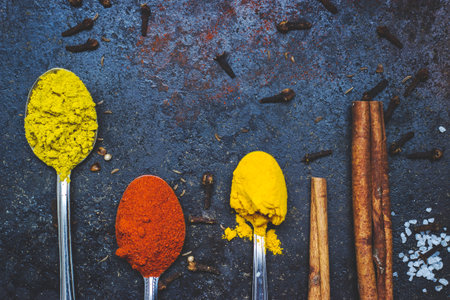 Tea spoons full of spices, on black background; with copy spaceの写真素材