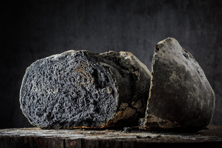 Bread of unusual black color on a dark background on a wooden tableの写真素材